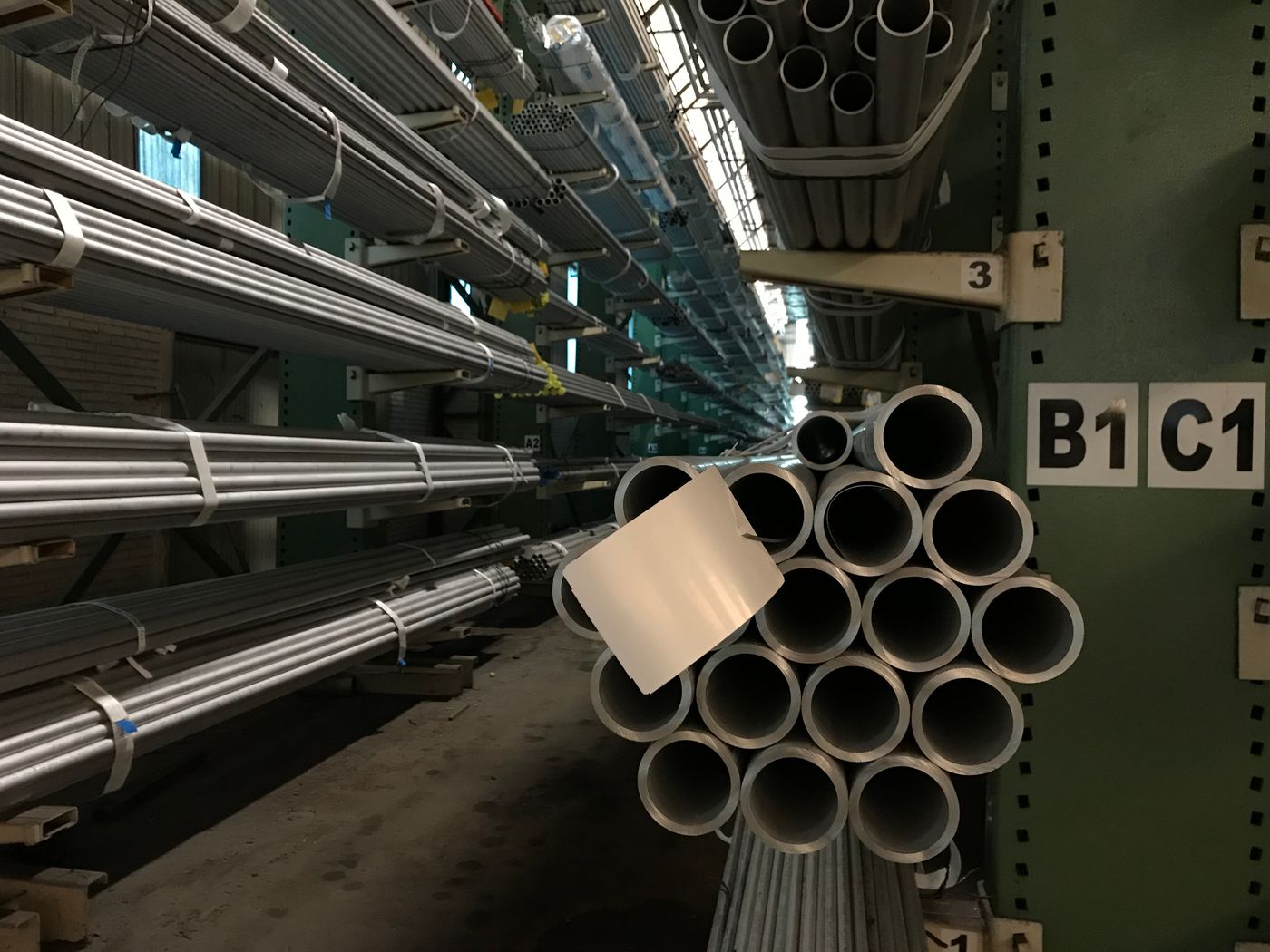 Galvanised round steel pipes stacked on a warehouse rack